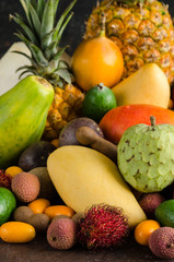 Healthy eating, varieity of tropical fruits on a dark background.