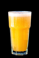 Yellow smoothie (orange, mandarin) in a large glass glass on a black background, isolated.