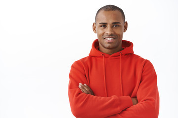 Close-up portrait of professional, successful young african-american man in red hoodie, cross arms chest, smiling satisfied, look determined and pleased, express confidence and satisfactory feeling