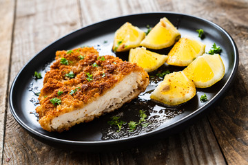 Pork chop with lemon and lemon on wooden background