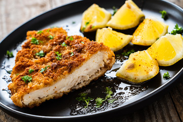 Pork chop with lemon and lemon on wooden background