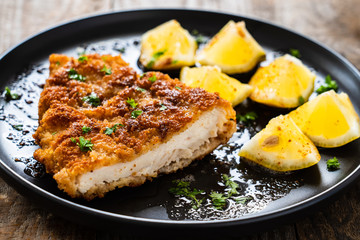 Pork chop with lemon and lemon on wooden background