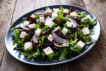  Beetroot salad with goat cheese on wooden background