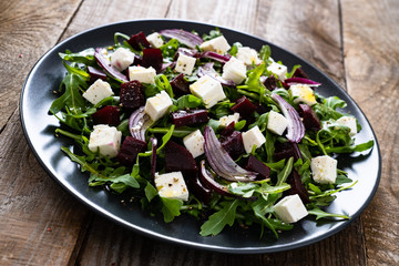  Beetroot salad with goat cheese on wooden background