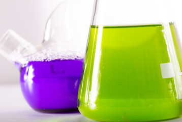 Beaker and retort with green and blue chemical reagent. Chemical experiment with Laboratory glass