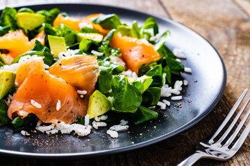 Salmon salad - smoked salmon white rice and vegetables on wooden table