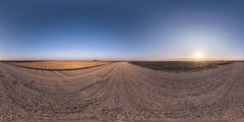 Fototapeta na wymiar full seamless spherical hdr panorama 360 degrees angle view on no traffic gravel road among fields in spring evening with clear sky in equirectangular projection, for VR AR virtual reality content