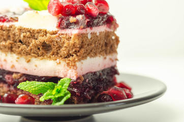 Colorful multi-layered cream chocolate cake with cherry jam and pomegranate