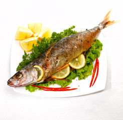 fried fish on a white plate on a kitchen table