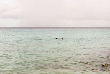 Tropical sea with two snorkeling people in the distance at Curacao