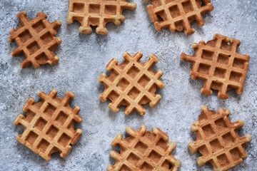Vanilla Belgian waffles on a concrete background.