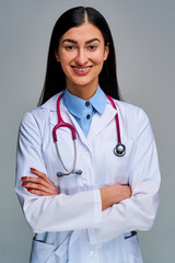 Happy girl doctor with a phonendoscope on her shoulders with arms crossed. Medical concept