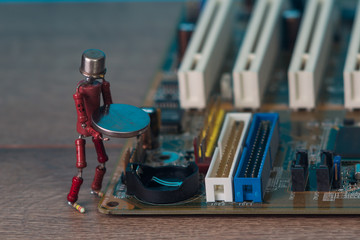 small human figure, made from resistors and transistor, helps to fix electronic computer board