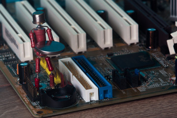 small human figure, made from resistors and transistor, helps to fix electronic computer board