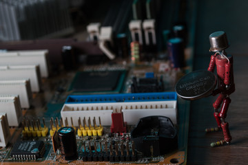 small human figure, made from resistors and transistor, helps to fix electronic computer board