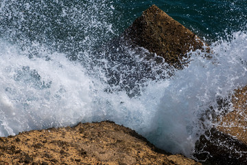 Waves in sea Splashing Waves. Danger sea wave crashing on rock coast with spray and foam before storm. Beautiful sea waves with foam of blue and turquoise color.