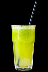 Green smoothie made from herbs and vegetables in a large glass glass on a black background, isolated