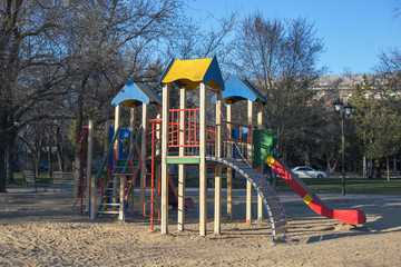 Colorful children playground on the yard in the public park in spring. Childhood concept