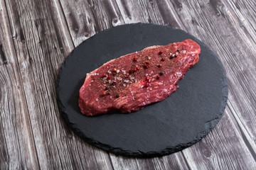 Raw fresh marbled meat and seasonings on dark background top view