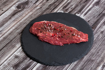 Raw fresh marbled meat and seasonings on dark background top view