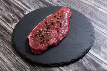 Raw fresh marbled meat and seasonings on dark background top view