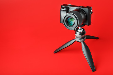 Professional camera on a tripod, on a red background. Record videos and photos for your blog, reportage