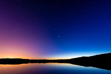Naklejka premium Late sunset on the lake. Beautiful night starry sky.