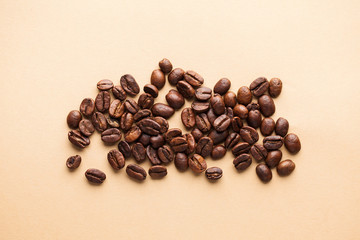  A handful of arabica coffee beans on a light background. Horizontal photo for coffee houses, screensavers, roasters