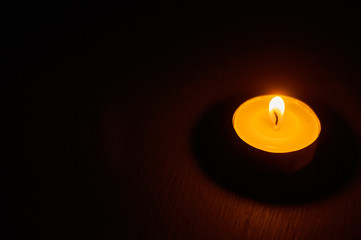 One burning circle candle on dark background