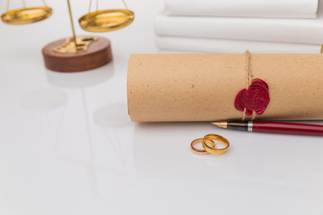 Divorce concept. Golden rings on the table with wooden hammer and money.