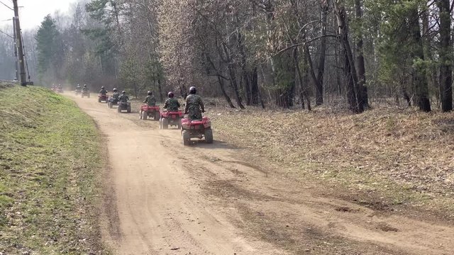 A row of ATV going on forest road