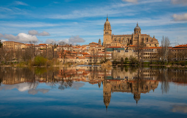 Fototapeta na wymiar View of the city of Salamanca and its Cathedral reflected in the calm waters of the Tormes river