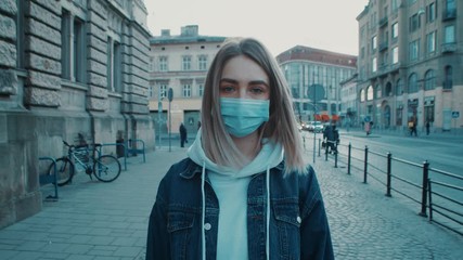 Young caucasian woman standing on the sreet and wearing protective mask virus covid19 coronavirus pandemic city pretty women focused on camera close up - Powered by Adobe