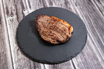 Grilled beef steak ribeye on dark wooden background top view