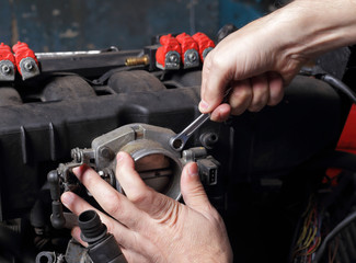 Car service - Engine repair mechanic hands with wrench