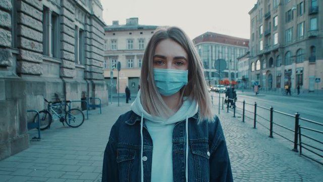 Young caucasian woman standing on the sreet and wearing protective mask virus covid19 coronavirus pandemic city pretty women focused on camera close up