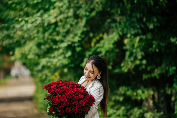 Woman with Spring Flower bouquet. Happy surprised model woman smelling flowers. Mother's Day. Springtime