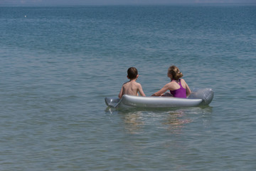Zwei Kinder auf der Luftmatratze im Meer