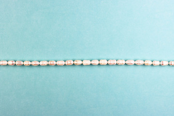 women's accessories made of pearls on a blue background, top view