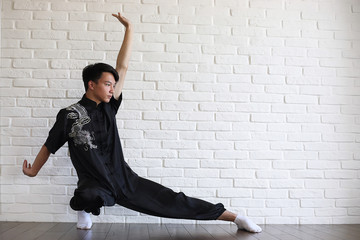 Asian young novice on a white brick wall