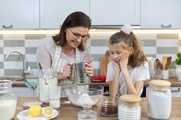 Mother and child preparing bakery together in home kitchen