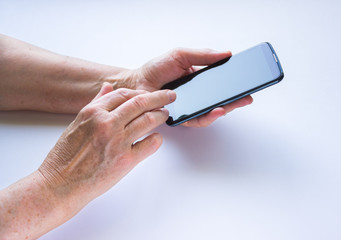 women's hands hold a black smartphone