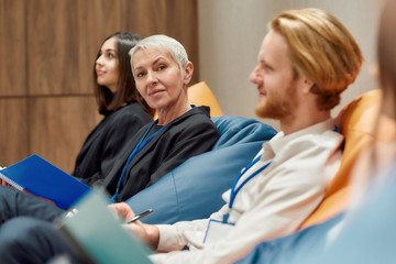 A lovable place for working. Middle-aged businesswoman looking at camera while making notes...