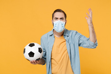 Angry man in face mask isolated on yellow background. Epidemic pandemic 2019-ncov sars covid-19 flu...