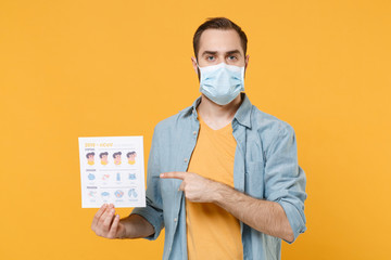 Young man in sterile face mask isolated on yellow background. Epidemic pandemic coronavirus...