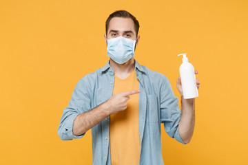 Young man in sterile face mask isolated on yellow background. Epidemic pandemic coronavirus...