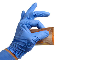 A hand in a medical glove holds the euro on a white background, isolated. Bribe concept