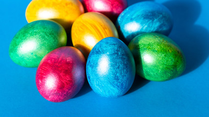 Colorful easter eggs on blue background. Happy Easter composition. Copy space.
