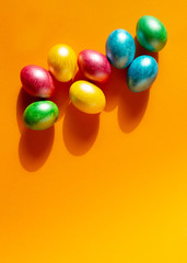 Colorful easter eggs on orange background. Happy Easter composition. Copy space.