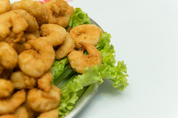 Closeup of delicious deep fried shrimps served with lime wedges and lettuce leaves